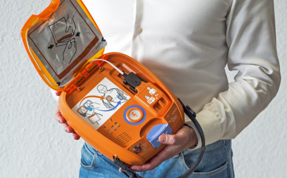 Mitarbeiter mit einem NIHON KOHDEN AED 3100 Defibrillator in der Hand