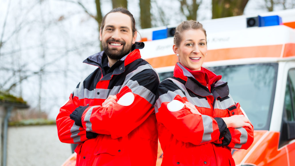 Zwei Rettungssanitäter vor einem Rettungswagen