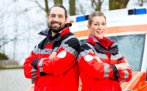 Zwei Rettungssanitäter vor einem Rettungswagen